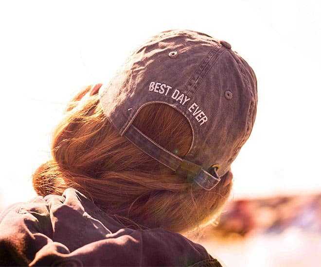 Woman wearing a hat with "Best Day Ever" stitched on the back of the hat