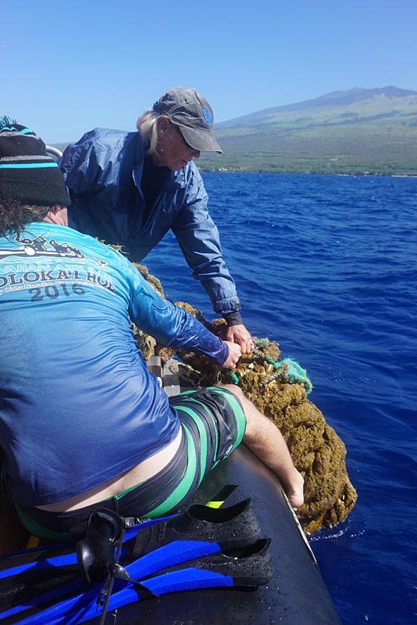 Men cleaning trash out of the ocean